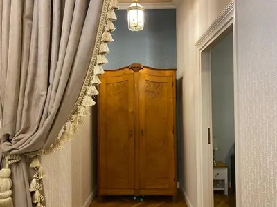 a room with a wooden cabinet next to a curtain at Radiance Residence in Kraków