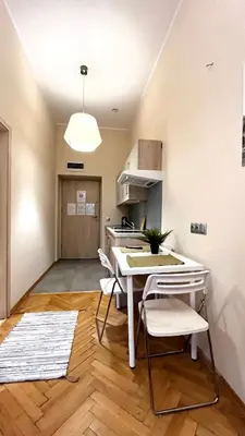 a kitchen with a table and chairs in a room at Homely Studio in Kraków