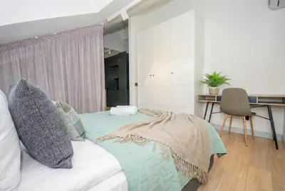 a bedroom with a bed with a desk and a chair at InPoint Sunny Studio next to Wawel Castle - Kossaka 5 Self Check-in in Kraków