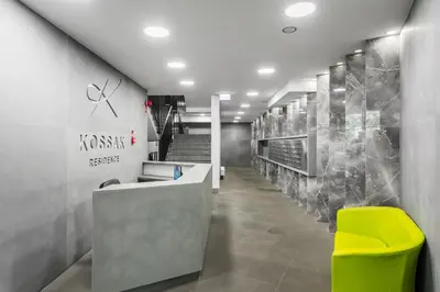 a lobby with a reception desk and a yellow chair at Premium Apartment in Kossak Residence in Kraków