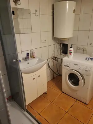 a bathroom with a washing machine and a sink at Grzegorzecka Room nr 1 in Kraków
