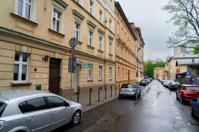 a street with cars parked on the side of a building at Asnyka Old Town in Kraków