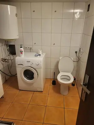 a small bathroom with a toilet and a washing machine at Grzegorzecka Room nr 5 in Kraków