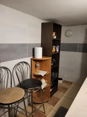 a room with two chairs and a table and a shelf at Grzegorzecka Room nr 5 in Kraków