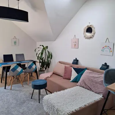 a living room with a couch and a table at Apartament Pastelowy in Kraków