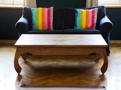 a black couch with colorful pillows and a coffee table at Stanislas Apartment in Kraków
