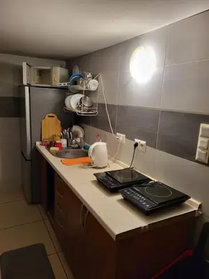 a kitchen with a counter with a sink and a refrigerator at Grzegorzecka Room nr 2 in Kraków