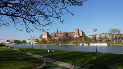 a view of a large building with a river in front at Luxor in Kraków