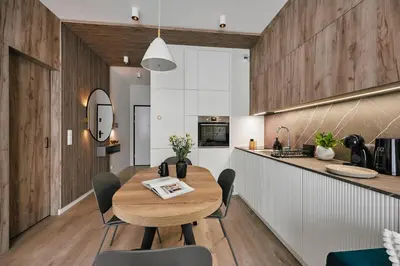 a kitchen and dining room with a wooden table and chairs at Golden Dreams Luxury Apartment 81 in Kraków