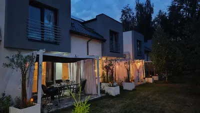 a house with a table in a backyard at night at Domek Niebieskie Marzenie in Chrzanów