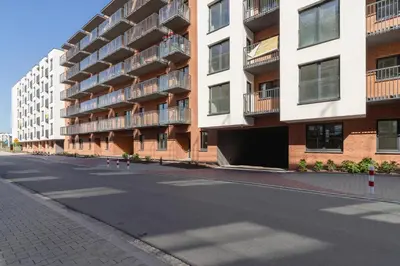 an empty street in front of an apartment building at Modern Apartment Podgorze with Parking by Noclegi Renters in Kraków