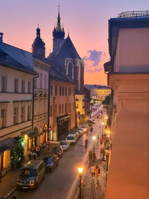 a city street at night with cars parked on the street at City Center Studio with a View in Kraków