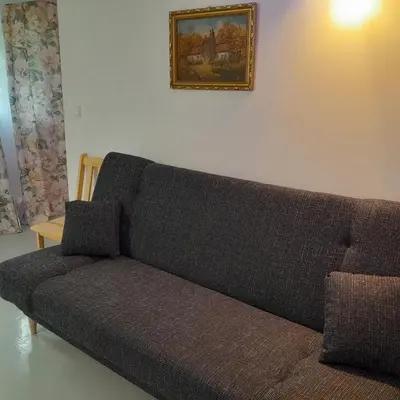 a couch in a living room with a picture on the wall at Domek Muchorek 1km od Energylandii in Zator