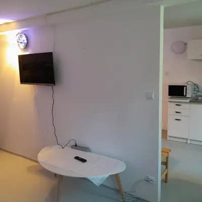 a room with a table and a tv on a wall at Domek Muchorek 1km od Energylandii in Zator