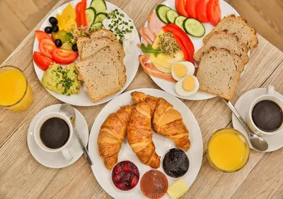 a table topped with plates of breakfast foods and coffee at Pastel Grove Suite - by Upstairs in Kraków