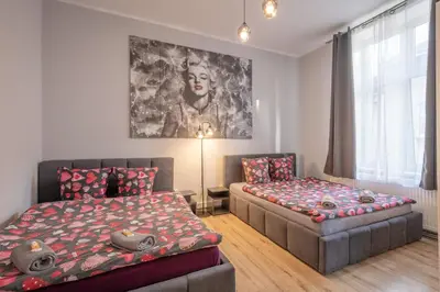 a bedroom with a bed and a window at Queen Apartments in Kraków