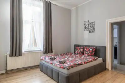 a room with two beds and a kitchen with a kitchen at Queen Apartments in Kraków