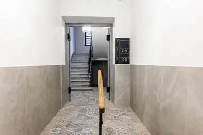 a hallway with stairs and a chalkboard on the wall at CracWoW K8 Apartments in Kraków
