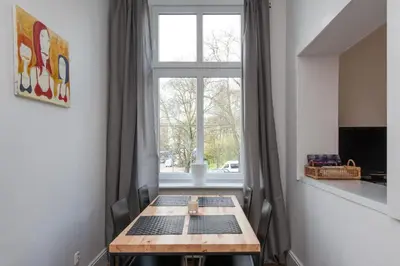 a wooden table in a room with a window at Krakow 25 Old Town Apartament in Kraków