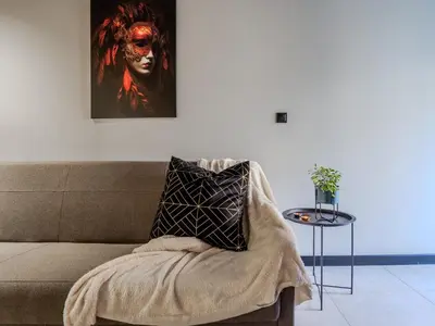 a couch with a blanket and a picture on the wall at Loft vistula old town apartament free parking in Kraków