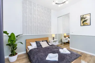 a bedroom with a bed with two towels on it at Nowoczesny apartament w ścisłym centrum Krakowa - by Upstairs in Kraków
