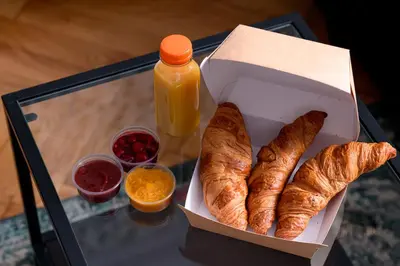 a box of croissants and a bottle of orange juice at Native Apartments Kościuszki 39/28 in Kraków