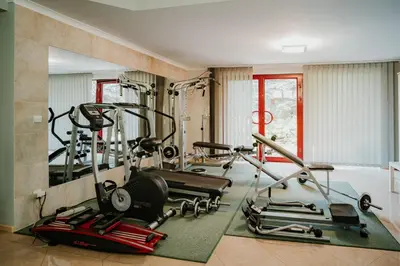 a gym with two tread machines and a mirror at Apartamenty Pod Dzwonkiem in Wadowice