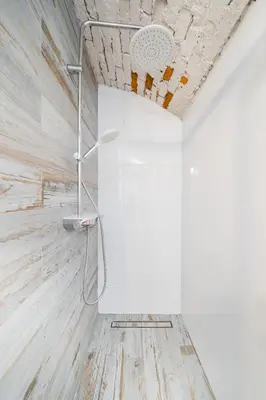 a shower in a bathroom with white walls at Vélo Apartment, High Standard, TV, WiFi in Kraków