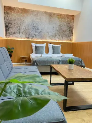 a living room with two beds and a table at Cube House Aparthotel in Kraków