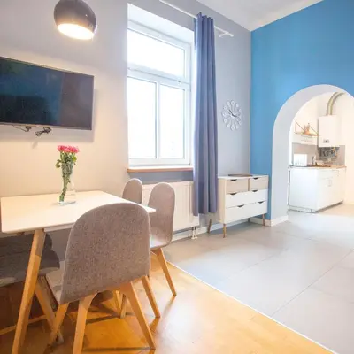 a dining room with blue walls and a table and chairs at Smart Old Town Apartment in Kraków