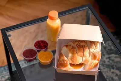 a box of bread and a bottle of orange juice at Native Apartments Kościuszki 39/22 in Kraków