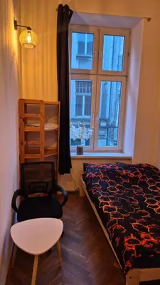 a bedroom with a bed and a chair and a window at Agnieszki Pokoj nr 2 in Kraków