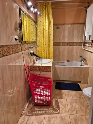 a bathroom with a sink and a red basket at Agnieszki Pokoj nr 2 in Kraków