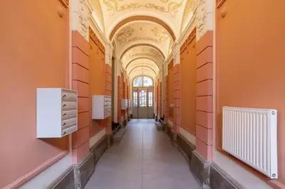 a hallway in a building with orange walls and a ceiling at Balcony Apartment - Kazimierz- Starowiślna 41 in Kraków