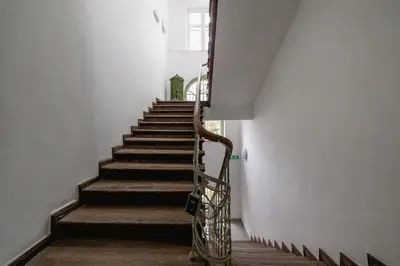 a stairway with a metal handrail and stairs at Balcony Apartment - Kazimierz- Starowiślna 41 in Kraków