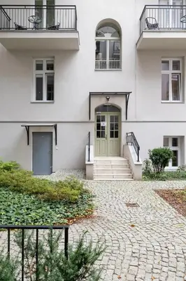 a white house with a green door and stairs at Apartment with Balcony - Kazimierz- Starowiślna 41 in Kraków