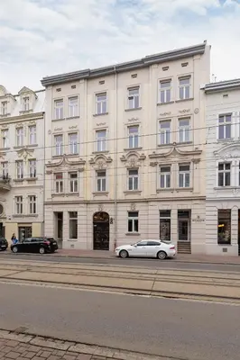 a white car parked in front of a large building at Studio with an AC - Kazimierz - Starowislna 41 in Kraków