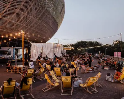 a crowd of people sitting in lawn chairs on a patio at Lema Tauron Arena Two Bedroom Apartment in Kraków