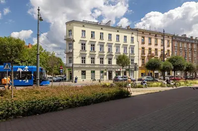 a building on a street with a bus in front of it at 1-Bedroom Apartment - Długa 65 Street in Kraków