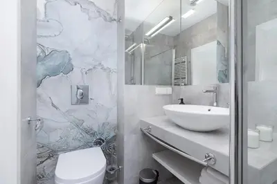 a bathroom with a white toilet and a sink at Cozy studio with a balcony - Rajska 3 street in Kraków