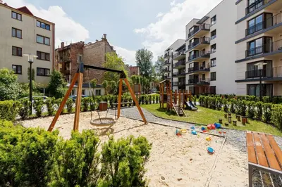 a playground with a swing set in a park at Podgórze Golden Oriole Apartment Cracow by Renters Prestige in Kraków