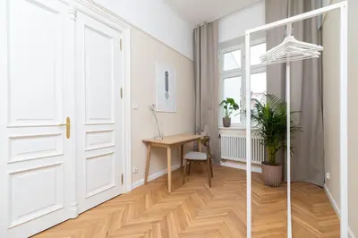 a hallway with a white door and a wooden table at 2 - bedroom apartment - Rejtana 10 in Kraków