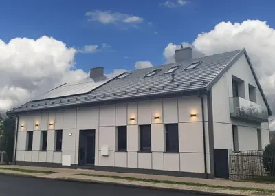 a white building with a black roof at Apartament Quiet Street 11, 6E in Oświęcim