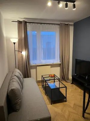 a living room with a couch and a glass table at Borkowska Corner in Kraków