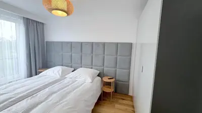 a bedroom with a large white bed and a window at MintKrak in Kraków