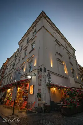 a large white building with a store on a street at Vintage Senacka 3 Apartment in Kraków