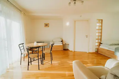a room with a table and chairs and a bed at Apartamenty pod Dzwonkiem in Wadowice