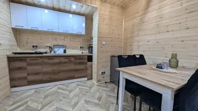 a kitchen with wooden walls and a table and a sink at Domek wypoczynkowy Górskie Zacisze II in Sidzina