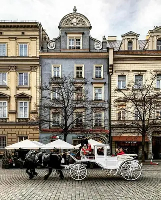 a horse drawn carriage in front of a building at Przytulny apartament w sercu Krakowa Old Town in Kraków