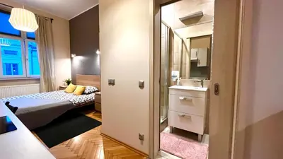 a small room with a bed and a mirror at Studio in City Center in Kraków